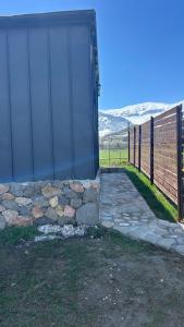 een poort met een stenen loopbrug naast een hek bij Shahdag Nature House in Qusar