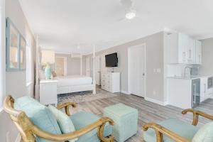 a white living room with a chair and a couch at GP57: 57 Grand Pavilion in Isle of Palms