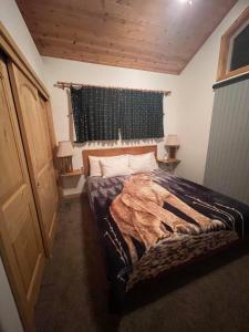 a bedroom with a bed and a window with a blanket at Mountainside Family Chalet in Yosemite West