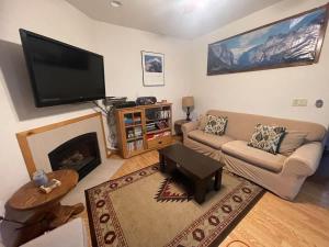 a living room with a couch and a flat screen tv at Mountainside Family Chalet in Yosemite West