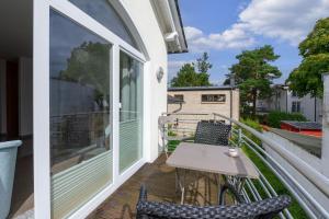 宾茨Villa A Cappella Binz - Wohnung C5的阳台配有桌椅。