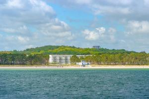 a beach with a large building on the shore at Strandresort Prora - Wohnung 213 in Binz