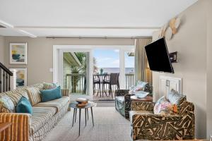 a living room with a couch and a tv at SG10D: 10D Seagrove Villa in Isle of Palms