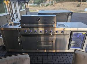 a stainless steel stove and sink on a patio at Modern Cabin Bungalow in Mariposa