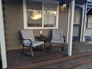 two chairs and a table on a porch at Modern Cabin Bungalow in Mariposa