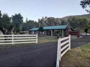 a house with a white fence and a house at Modern Cabin Bungalow in Mariposa