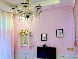 a room with a pink wall with a chandelier at The Cozy Nook in Zhangjiajie