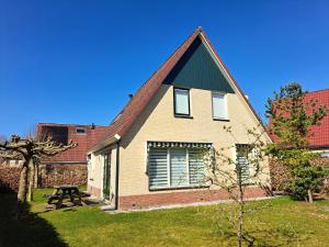ein Haus mit einem Picknicktisch davor in der Unterkunft Comfortabel landhuis voor rust en ontspanning in Schoonloo