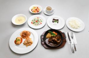 木更津市にあるビジネスホテル旅館本陣の食べ物の皿とご飯の入ったボウルが置かれたテーブル