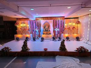 a stage with a table with some statues on it at Hotel Mangala Temple View in Guruvāyūr