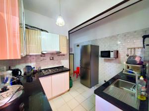 a kitchen with a sink and a refrigerator at Les Alizés appartement meublé 1, alimenté par énergie solaire in Toamasina
