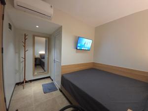 a bedroom with a bed and a tv on the wall at Hello Inn permata hijau in Stasiun Tawang