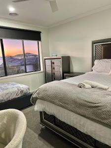a bedroom with two beds and a large window at Mahzan on Kilcunda - Ensuite 1 in Truganina