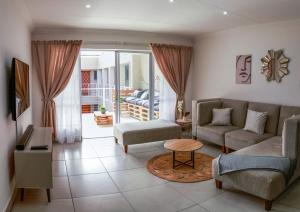 a living room with a couch and a table at Neptunes Hideaway in Jeffreys Bay