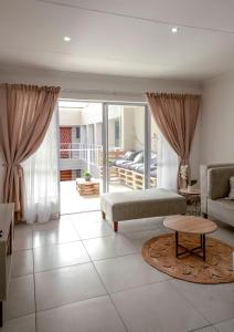 a living room with a couch and a table at Neptunes Hideaway in Jeffreys Bay