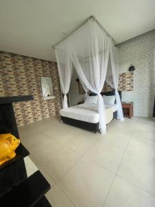 a bedroom with a bed with a canopy at bali amed feel home in Amed