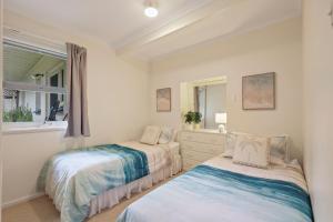 two beds in a room with a window at Lovely Unit with Glorious Sea Views in McCracken