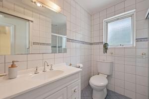 a bathroom with a sink and a toilet and a mirror at Lovely Unit with Glorious Sea Views in McCracken +23 photos