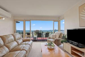 a living room with a couch and a flat screen tv at Lovely Unit with Glorious Sea Views in McCracken