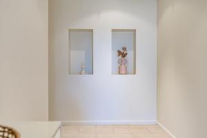 a white wall with three pictures of a vase on it at Bluffview B&B - Luxury Oceanviews - Wi-Fi - No Linen Included in McCracken