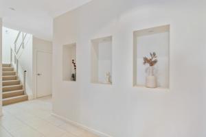 a white hallway with white walls and a staircase at Bluffview B&B - Luxury Oceanviews - Wi-Fi - No Linen Included in McCracken