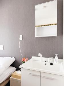 a bathroom with a white sink next to a bed at 青麦旅館台東店 in Tokyo +80 photos