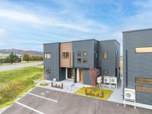 a large gray house in the middle of a street at Orvia Yig Villa in Furano