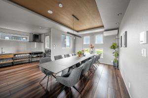 a dining room with a long table and chairs at Orvia Yig Villa in Furano