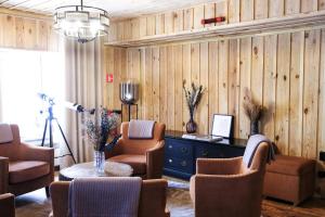 a living room with chairs and a table and a lamp at Le Mont in Almaty