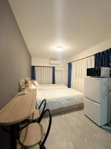 a bedroom with a bed and a table and chairs at 青麦旅館台東店 in Tokyo