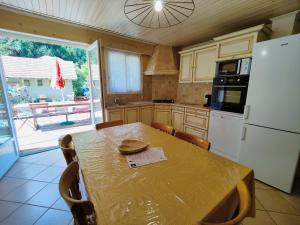 Le Lauzet-UbayeにあるLocation MarjoRI - T3 Le Kakarikiのテーブルと白い冷蔵庫のあるキッチン