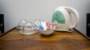 una mesa con una máquina de coser y un cuenco con utensilios en Woodsy Villa, en Sigiriya