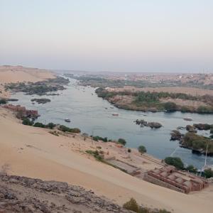Nag` el-RamlaにあるHouseboat Hotel and Nile Cruises Zainobaの砂漠の川とそこに浮かぶボート