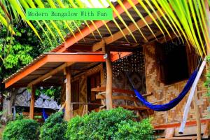 a house with a hammock in front of it at Asama Bungalow in Ko Lanta