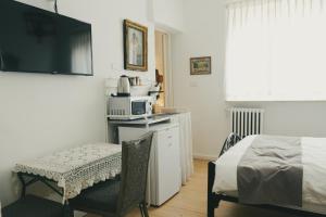 a bedroom with a bed and a microwave and a chair at Tzefania Hotel in Jerusalem