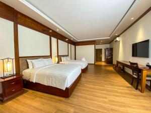 a hotel room with two beds and a desk at Phuong Nam Resort in Thuan An