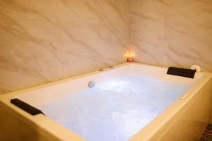 a bath tub with a ball in the water at Hotel Super Stay in Ujjain +21 photos