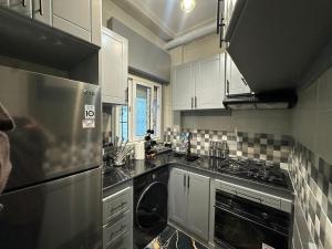a kitchen with white cabinets and a dishwasher at The HQ in Hydra