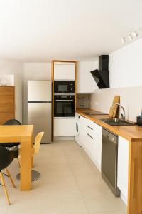 a kitchen with white cabinets and a wooden table at VILLA MAR in Cala'n Bosch