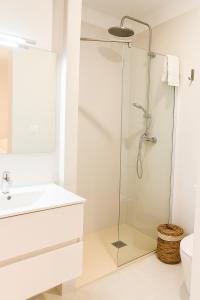 a white bathroom with a glass shower stall at VILLA MAR in Cala'n Bosch