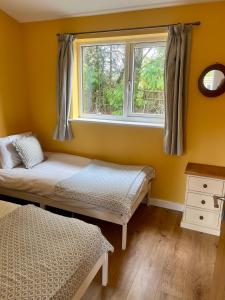 Un dormitorio con dos camas y una ventana en Southend Long Barn, en Ogbourne Saint George