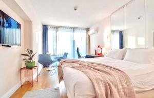 a bedroom with a white bed and a desk and chairs at Orbi City Amazing Apartments in Batumi +69 photos