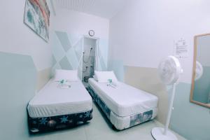 a hospital room with two beds and a fan at RedDoorz near Mariners Legazpi in Legazpi