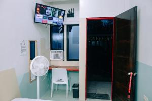 a kitchen with a refrigerator and a table with a fan at RedDoorz near Mariners Legazpi in Legazpi +52 photos