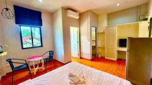 a bedroom with a bed and a table and chairs at Cozy Bay Rawai in Phuket Town