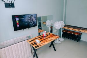 a room with a table and a tv on the wall at RedDoorz near Mariners Legazpi in Legazpi