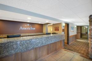 a lobby of an american inn with a reception counter at AmericInn by Wyndham Lincoln North in Lincoln