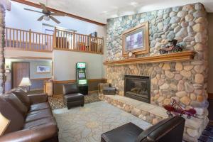 a living room with a stone fireplace and a couch at AmericInn by Wyndham Lincoln North in Lincoln