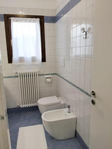 bagno bianco con servizi igienici e finestra di Alla Stazione - alloggio con parcheggio Spresiano a Spresiano