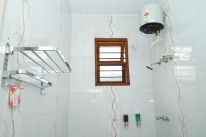y baño con ducha y ventana. en Deepam Haven Inn, en Gūduvāncheri 41 fotos más